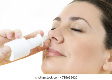 Relaxed young woman using nasal spray