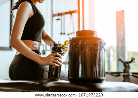 Relaxing after training.beautiful young woman looking away while sitting  at gym.young female at gym taking a break from workout.woman brewing protein shake. 商業照片 © 