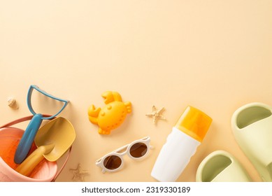 Relaxing beach getaway with your infant: top-down view of toys, sandcastle tools, sunscreen bottle, glasses, rubber slippers, shell, starfish on calming beige background, offering space for text or ad - Powered by Shutterstock