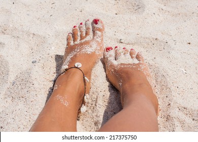 Relaxing at a beach, with your feet on the white sand.