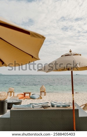 A relaxing beachfront setup in Koh Lipe, Thailand, featuring umbrellas, cushions, and ocean views. A serene tropical escape with cozy seating and a picturesque seaside atmosphere