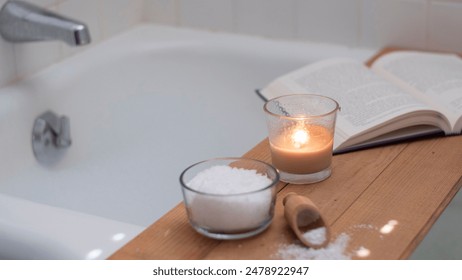 Relaxing bubble bath with bath salts, candle and book. White Tub with silver faucet - Powered by Shutterstock