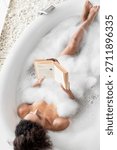 Relaxing in a Bubble Bath While Reading a Book in a Serene Bathroom Setting