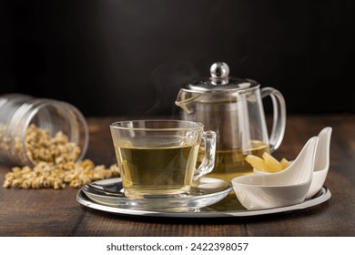 Relaxing chamomile tea in glass cup with lemon slices and honey next to it on wooden table. - Powered by Shutterstock