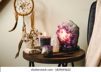 Relaxing Home Shrine With Relaxing Objects, Amethyst Cluster Geode Lamp Illuminated, Scented Candle Burning, Selenite Tower Stone, Crystal Wire Tree And Dream Catcher.