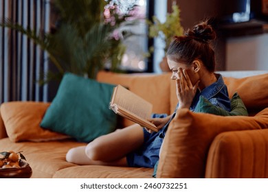 Relaxing at Home Woman Sitting on Couch with Eyes Closed and Book in Front of Her, Enjoying Peaceful Moment - Powered by Shutterstock