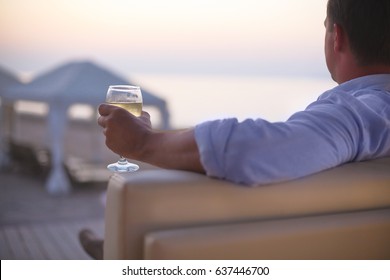 Relaxing man with glass of white wine in the beach bar


 - Powered by Shutterstock