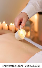 Relaxing Massage And Aromatherapy With Burning Candle And Wax. Back Of Unrecognizable Woman, Lying In A Massage Parlor.