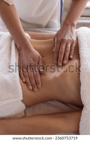 relaxing massage and body shaping massage, lymphatic drainage, manual and aesthetic procedures, hands massaging belly in spa salon.