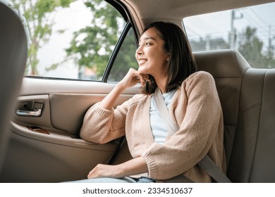 Relaxing moment of beautiful woman sitting in car back seats with safety belt and look out in the window. Female happy in car while traveling on the road to your destination. - Powered by Shutterstock