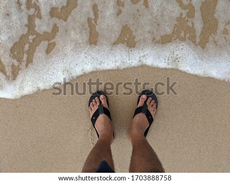 Relaxing on beach with foot picture and sandals / footwear