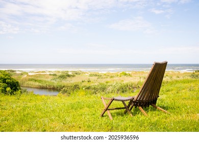 relaxing on a wooden deck chair on the beach - Powered by Shutterstock