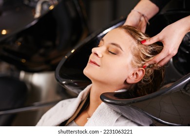 Relaxing at the salon. Shot of a young woman having her hair washed at a hair salon. - Powered by Shutterstock