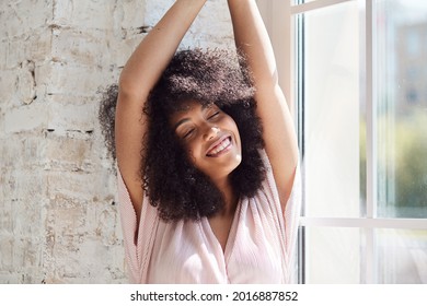 Relaxing Smiling Young Black Woman Is Sitting Woman Sitting Near Window, Resting, Meditating, Napping, Enjoying A Nice Stress-free Weekend Time Alone In Her Home. Pause In Remote Work.