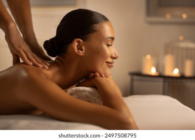 Relaxing spa treatment. European woman receiving back massage from professional masseuse at beauty salon, side view, copy space - Powered by Shutterstock