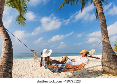 Relaxing Time In Kuredu, Maldives On Hammock With Beach And Sea In The Background