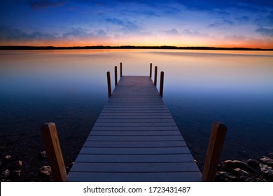 Relaxing View Of Dock Going Out Into Sunset Over Lake