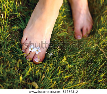 Relaxing woman feet among white flowers