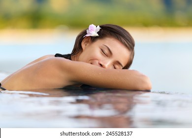 Relaxing Woman In Luxury Hotel Pool On Holidays - Vacation Travel. Asian Young Female Person Sleeping In Pool Spa At Hotel Resort In An Exotic Getaway.