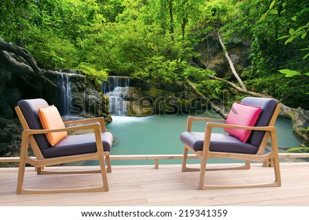 relaxing wooden desk on wood terrace against beautiful waterfalls in deep forest use for relax time in pure nature and refreshing time