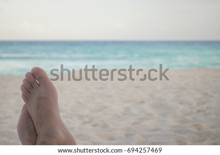 Relaxing with your feet up on a beach chair overlooking the blue Caribbean sea.