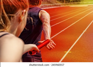 Relay race handing over from woman to man - Powered by Shutterstock