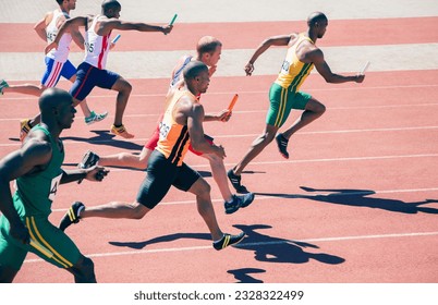 Relay runners racing on track - Powered by Shutterstock