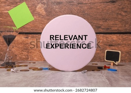 RELEVANT EXPERIENCE text on notebook with pen, calculator and chart on a grey background