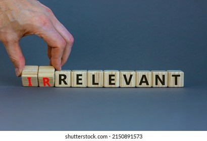 Relevant or irrelevant symbol. Businessman turns wooden cubes changes the word irrelevant to relevant. Beautiful grey table grey background. Business, relevant or irrelevant concept. Copy space.