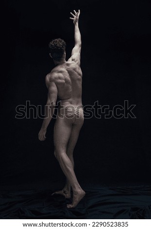 Relief body shape. Full-length portrait of handsome shirtless man posing in underwear against black studio background. Concept of male body aesthetics, men's beauty, inspiration, art