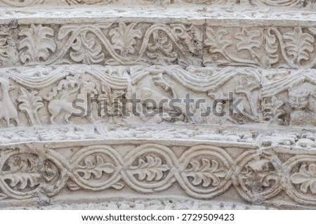 A relief pattern on the archivolt of St. Demetrius Cathedral in Vladimir, Russia. Lion, wolf, bird, floral ornament