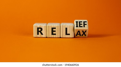 Relief and relax symbol. Turned a cube and changed the word 'relax' to 'relief'. Beautiful orange background. Business, relief and relax concept. Copy space. - Shutterstock ID 1940660926