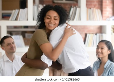 Relieved Smiling Black Woman Hug With Friend Showing Support And Empathy At Group Therapy Session, Diverse People Embrace Help Overcome Psychological Problems Or Addiction At Counselling Or Treatment