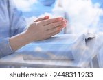 Religion. Double exposure of sky and Christian woman praying over Bible at table, closeup