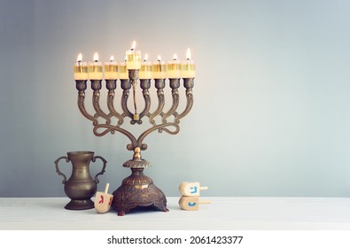 religiöses Bild des jüdischen Urlaubs Hanukka Hintergrund mit Menorah (traditioneller Candelabra) und Spinnerei-Spielzeug