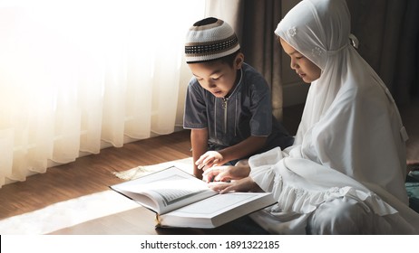 Religious Asian Muslim Kids Learn  The Quran And Study Islam After Pray To God At Home .Sunset Light Shining Through The Window.Peaceful And Marvelous Warm Climate. 