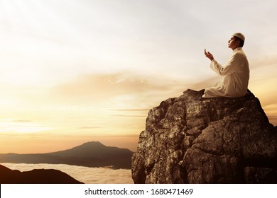 Religious Asian Muslim Man Praying On Top Of Mountain