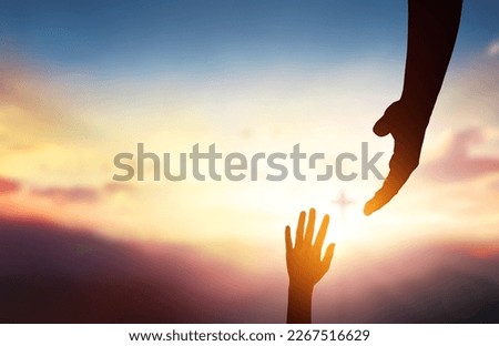 religious concept,God's helping hand and cross on sunset background