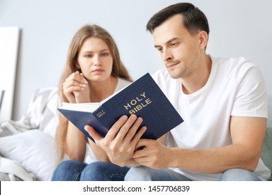 Religious Couple Reading Bible At Home