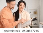 Religious couple reading Holy Bible in kitchen