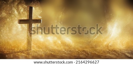 Religious cross in abstract wallpaper with shining gold sparkles and radiant lights. Symbolism of heaven or the resurrection.