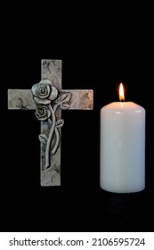 Religious cross and burning candle with black background and copy space for condolence text on the right side of the images. Condolence and sympathy concept. 