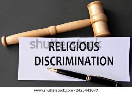 RELIGIOUS DISCRIMINATION - words on white paper on dark background with judge's gavel