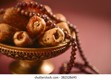 Religious food and objects. Close up of arabic dates and rosary.