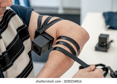 Religious jew places a black leather tefillin on his left hand with a jewish prayer inside. Religious traditions of the jewish people