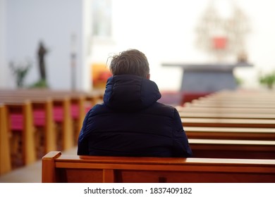 Religious middle age man praying and meditating in catholic church. Person begging for forgiveness and blessing from God. Catholicism is Christianity religion.