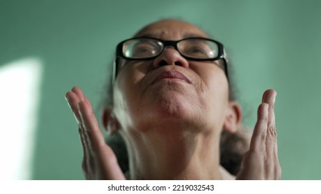 Religious Older Senior Hispanic Woman Praying To God. Spiritual South American Female Senior Person Looking Up Closeup Face In Prayer