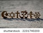 Religious symbols on sand. Christianity, Islam, Judaism, Orthodoxy Buddhism and Hinduism. Interreligious or interfaith concept.
