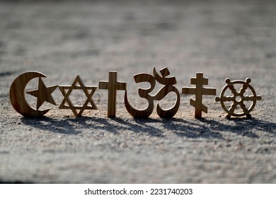 Religious symbols on sand. Christianity, Islam, Judaism, Orthodoxy Buddhism and Hinduism. Interreligious or interfaith concept.
					