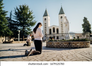 Religious woman praying to God and Virgin Mary in Medjugorje.Woman in emotional stress and pain.Christianity.Strong religion,faith and hope concept.Spiritual healing.Enlightenment